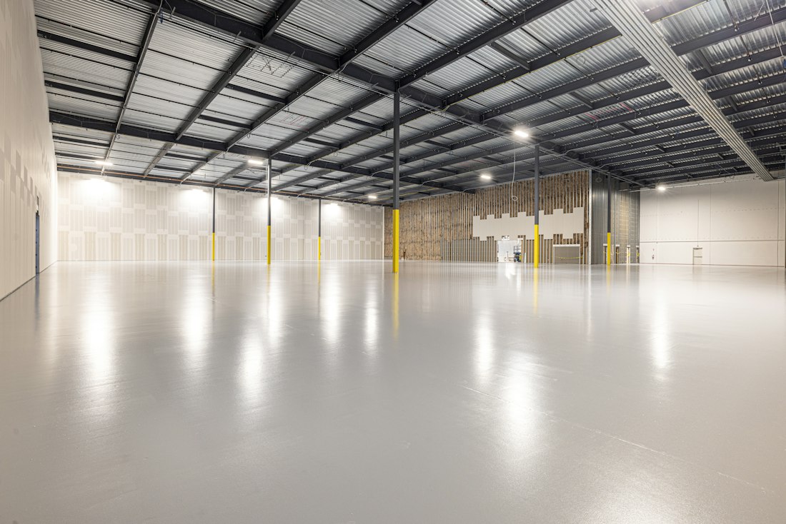 A clean, empty commercial warehouse interior with bright lighting